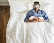 Man-asleep-in-bed-wearing-eyemask-and-pyjamas.jpg